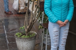 Young woman standing at a Cambista (street money changer) in Lima Peru