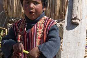 Young boy living among the Uru people on floating islands in Lake Titicaca near Puno Peru