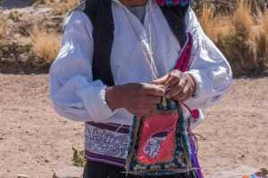Indigenous knitting man on the Island of Taquile in Lake Titicaca Peru